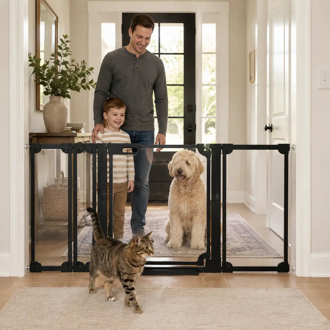 A family smiling behind a FairyBaby clear acrylic baby gate installed in a modern home doorway with a golden doodle dog and a cat walking through.