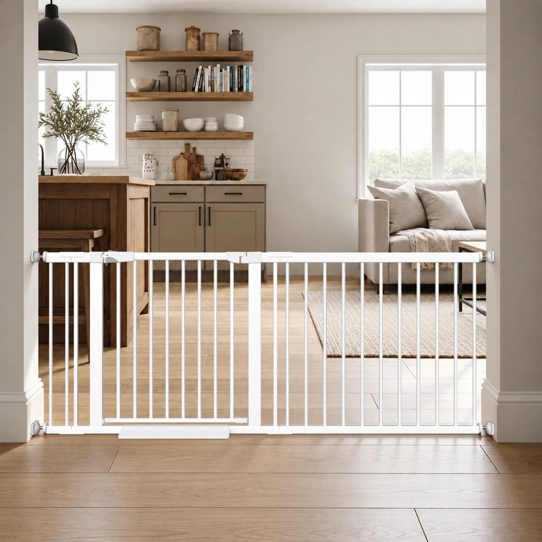 Extra wide white baby gate with door installed using pressure mounts in a kitchen and living room doorway.