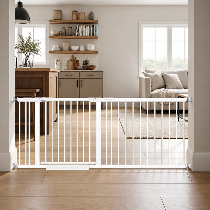 Extra wide white baby gate with door installed using pressure mounts in a kitchen and living room doorway.